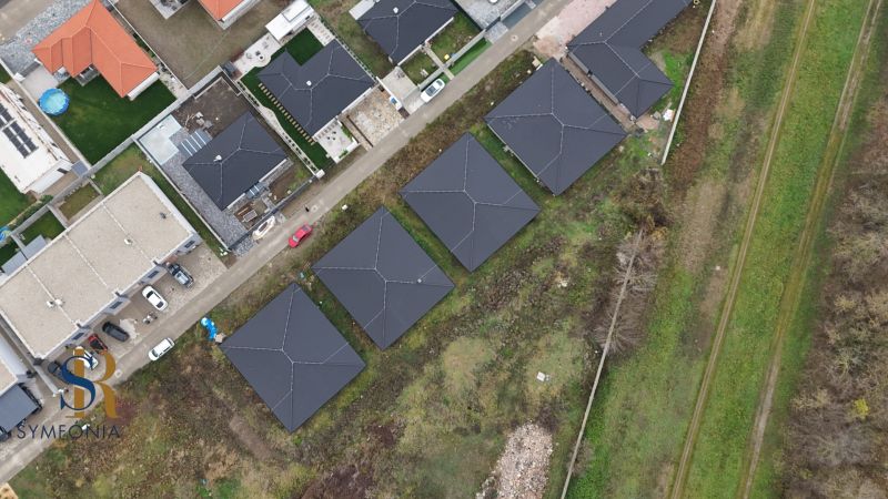 Moderný 4-izbový dom v tichej lokalite Šale – bez rezervačnej zálohy  - Letecký pohľad na rodinné domy v Šali vedľa poľnej cesty a zelenej oblasti.