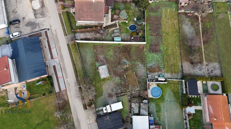 NOVÁ CENA Rovinatý pozemok v Pate 713 m² - bez rezervačnej zálohy - Letecký pohľad na pozemky na bývanie v obci Pata so záhradami a bazénom.