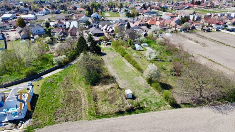 Priestor pre váš vysnívaný domov – pozemok 1114 m² - Horné Topoľníky - Pohľad na pozemky na bývanie v Topoľníkoch s viditeľnými záhradami a stavbami.