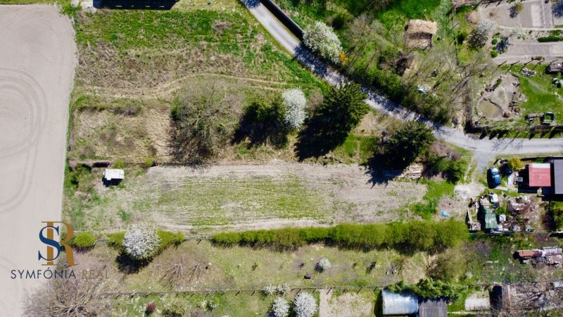 Priestor pre váš vysnívaný domov – pozemok 1114 m² - Horné Topoľníky - Letecký pohľad na pozemky na bývanie v Topoľníkoch, obklopené zeleňou a cestou.