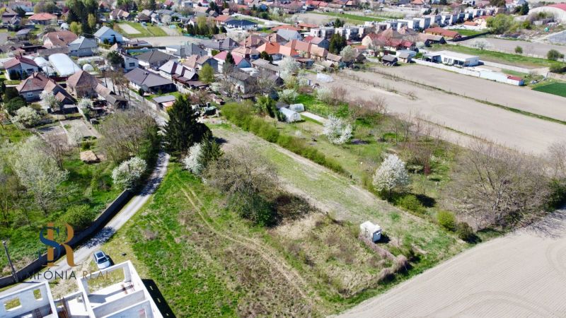 Priestor pre váš vysnívaný domov – pozemok 1114 m² - Horné Topoľníky - Záber na pozemky - bývanie v Topoľníkoch s okolitými domami a zeleňou.