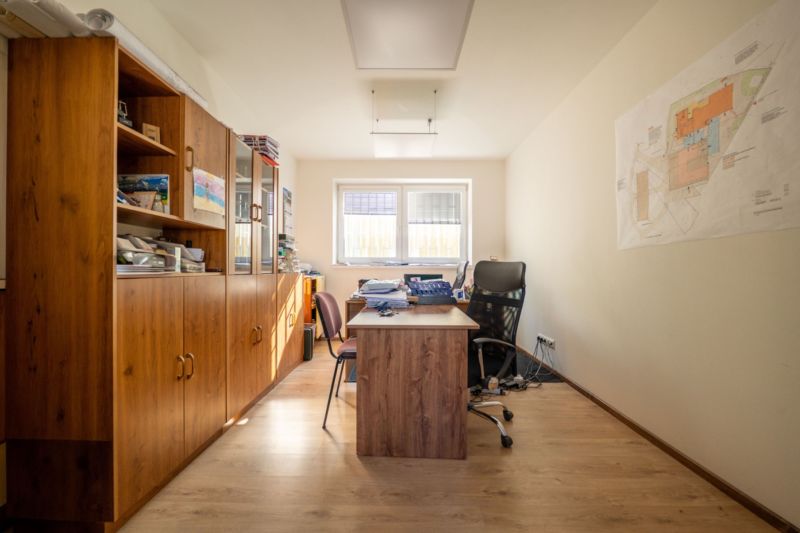 PREVÁDZKOVÝ AREÁL– HALA, ADMINISTRATÍVA, POZEMOK 1405 m² - B. Bystrica - Kancelária so stolom, stoličkami, skriňou a podlahou s dreveným dekorom. Zvláštne nehnuteľnosti.
