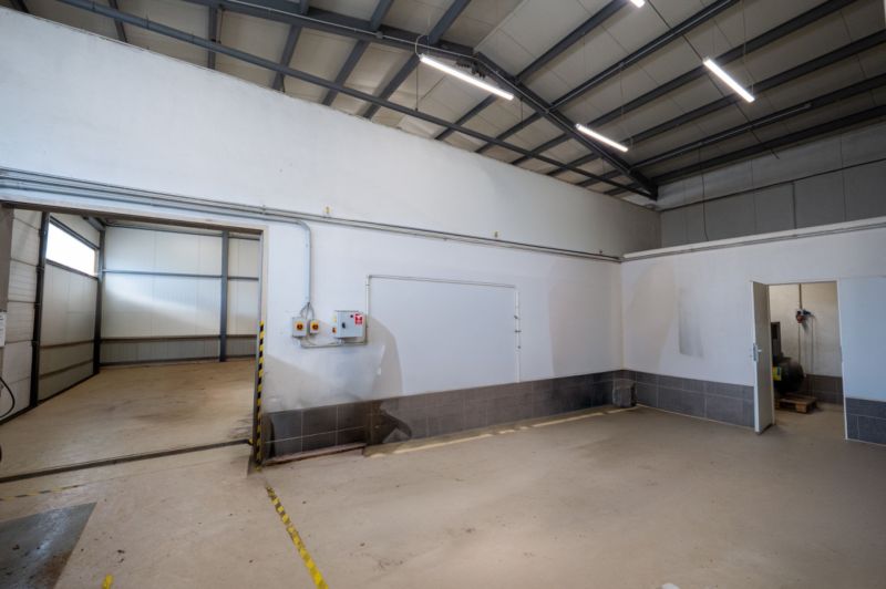 PREVÁDZKOVÝ AREÁL– HALA, ADMINISTRATÍVA, POZEMOK 1405 m² - B. Bystrica - Industriálny interiér s bielymi stenami a betónovou podlahou. Zvláštne nehnuteľnosti.