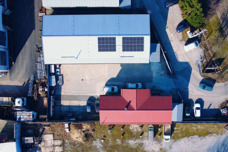 PREVÁDZKOVÝ AREÁL– HALA, ADMINISTRATÍVA, POZEMOK 1405 m² - B. Bystrica - Strechy budov so solárnymi panelmi a parkovisko, Stavebná v Majeri, Banská Bystrica.
