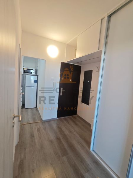 Na prenájom 1 izbový byt, 34 m2, Bratislava, Petržalka, Lachova ulica - Vstupná chodba so vstavanými skriňami a podlahou s dreveným dekorom v 1-izbovom byte.