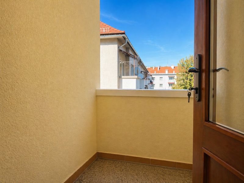 Na predaj priestranný 4-izbový byt - Robotnícka ulica, Banská Bystrica - Balkón v 4-izbovom byte s výhľadom na strechy a stromy.
