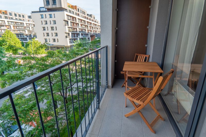 I Slnečnice – Zóna mesto moderný 1-izb byt s loggiou - Balkón 1-izbového bytu na ulici Zuzany Chalupovej, Bratislava - Petržalka s dreveným nábytkom.
