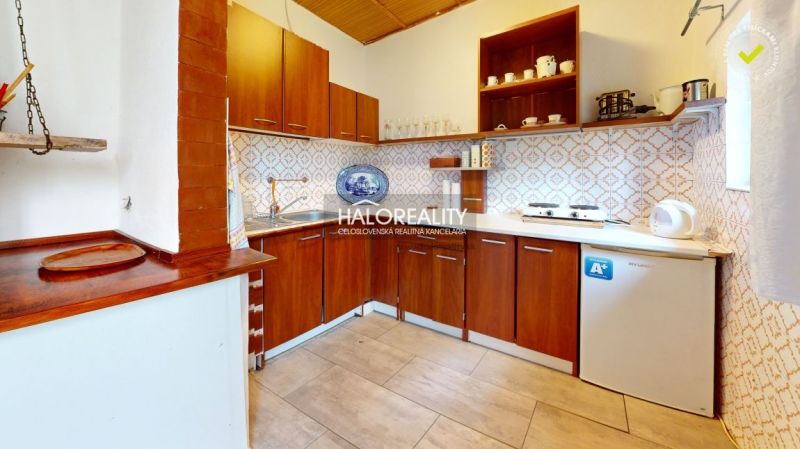 REZERVOVANÉ - Predaj, chata Ružiná - EXKLUZÍVNE HALO... - Kuchyňa v chate s dreveným nábytkom a vzorovanými obkladmi na stenách.