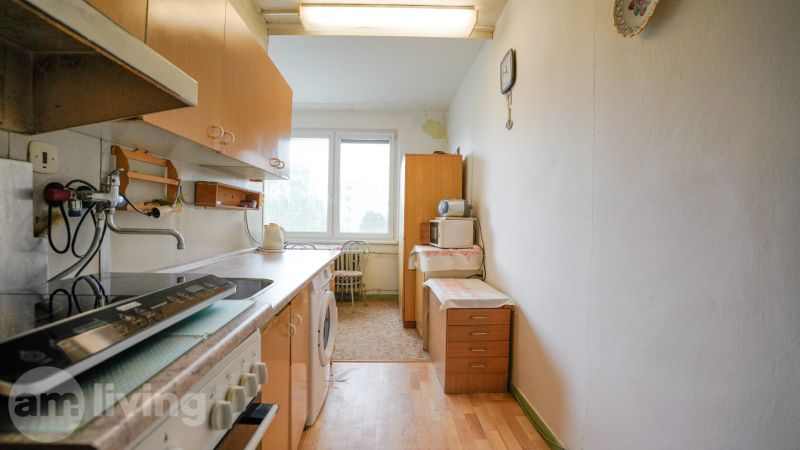 NOVINKA - 2 izbový + loggia + výťah v meste NOVÁ DUBNICA - Kuchyňa v 2-izbovom byte s podlahou s dreveným dekorom a základným vybavením.
