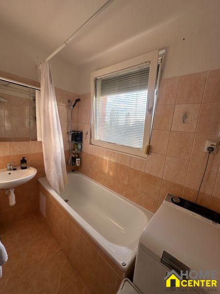 PREDAJ : 3 IZBOVÝ BYT S BALKÓNOM, KOMÁRNO  - Kúpeľňa v 3-izbovom byte s vaňou, umývadlom a práčkou, dlažba s teplými tónmi.