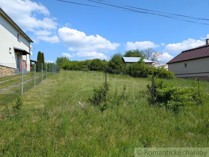Slnečný stavebný pozemok 1 186 m² - Karná | možnosť dokúpiť 1 ha - Pozemky - bývanie v Karnej, trávnatá plocha s oplotením a priľahlými budovami.