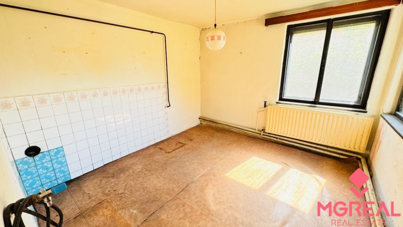 Na predaj 6-izbový rodinný dom (dvojdom) v Pažiti, pozemok 1445 m² - Nevybavená miestnosť s oknom, radiátorom a podlahou s dreveným dekorom v Rodinnom dome.