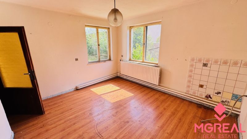 Na predaj 6-izbový rodinný dom (dvojdom) v Pažiti, pozemok 1445 m² - Priestranná izba s podlahou s dreveným dekorom v rodinnom dome.