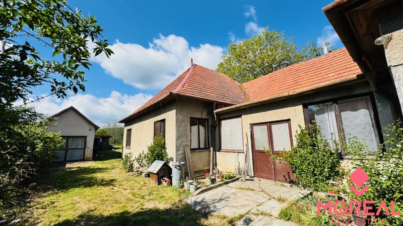 Na predaj 6-izbový rodinný dom (dvojdom) v Pažiti, pozemok 1445 m² - Rodinný dom v Pažiti s červenou strechou a prechodom do záhrady.