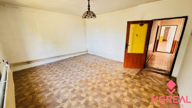 Na predaj 6-izbový rodinný dom (dvojdom) v Pažiti, pozemok 1445 m² - Izba s podlahou s dreveným dekorom a lampou v rodinnom dome.
