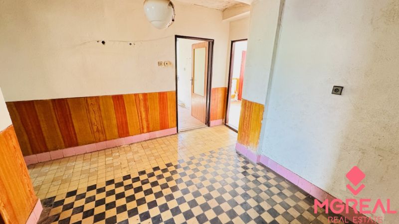 Na predaj 6-izbový rodinný dom (dvojdom) v Pažiti, pozemok 1445 m² - Interiér rodinného domu s dlaždicovou podlahou a drevodekorom na stenách.