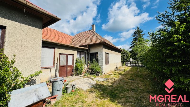 Na predaj 6-izbový rodinný dom (dvojdom) v Pažiti, pozemok 1445 m² - Rodinný dom v Pažiti s dvoma vstupmi, okná so sieťami, vedľa úzka záhrada.