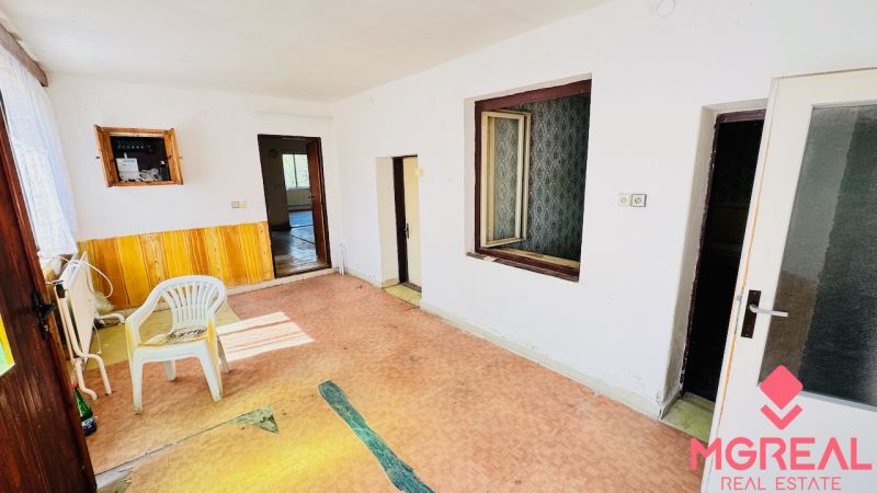 Na predaj 6-izbový rodinný dom (dvojdom) v Pažiti, pozemok 1445 m² - Interiér rodinného domu s plastovou stoličkou, dverami a elektrickou skrinkou na stene.
