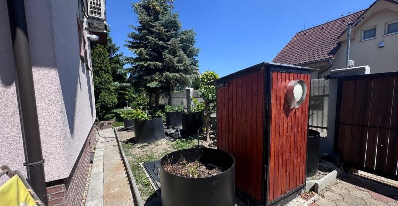 Rodinný dom v Dunajskej Lužnej  - Rodinný dom na Nových Košariskách v Dunajskej Lužnej s prístreškom a zeleným pozadím.