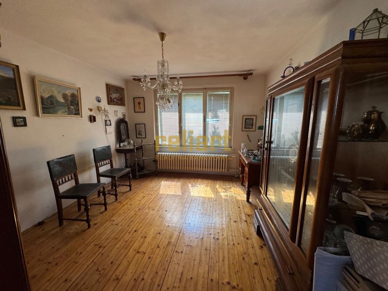 Krásny pozemok so starším domom Na Riviére, vhodný aj na investíciu  - Izba v rodinnom dome s dreveným dekorom, vintage nábytkom a množstvom obrazov na stenách.