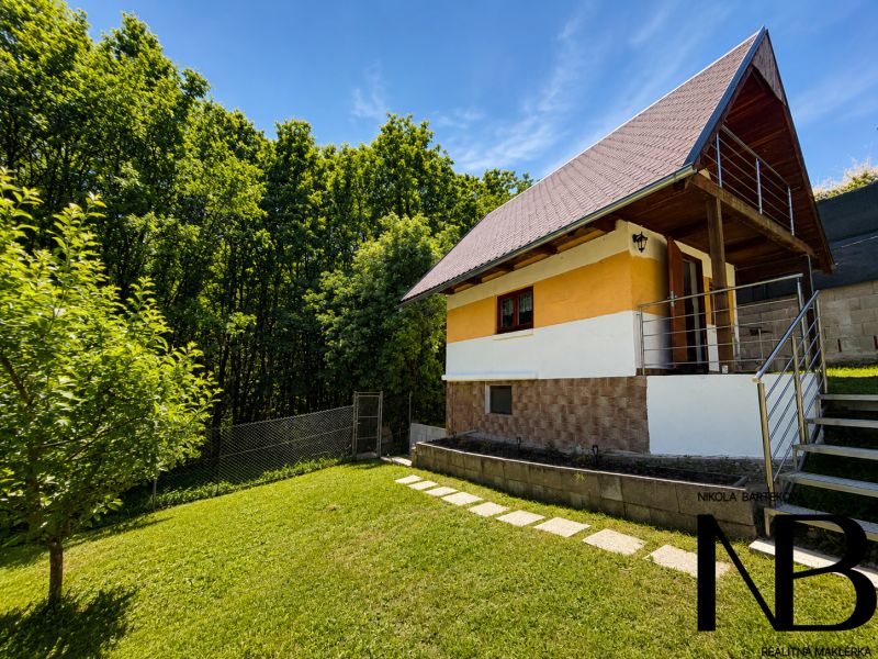 Záhrada s murovanou chatkou a výhľadom, Považská Bystrica -Klučina - Chata na ulici Klučina v Považskej Bystrici obklopená zeleňou a trávnikom.