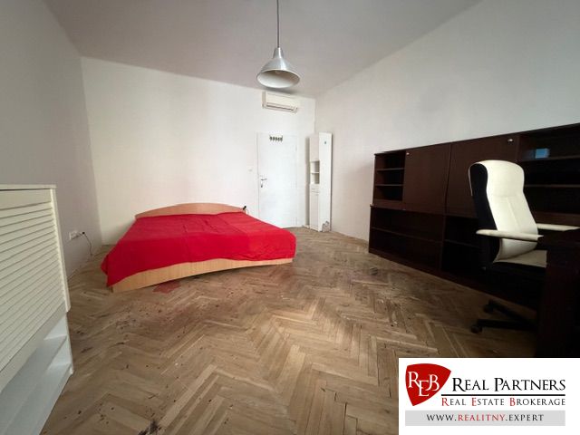 Predaj 3 izbový byt, 86 m2, Francisciho ul, Staré mesto, BAI . - Izba s posteľou, písacím stolom a podlahou s dreveným dekorom v 3-izbovom byte.