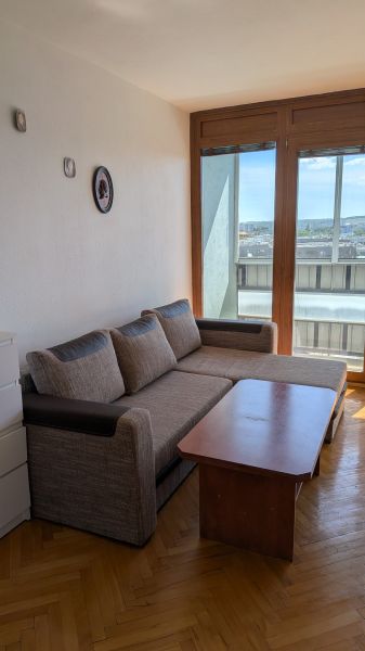3 izbový byt v centre mesta na Štúrovej ulici s krásnym výhľadom - Obývacia izba v 3-izbovom byte s pohovkou, konferenčným stolíkom a podlahou s dreveným dekorom.