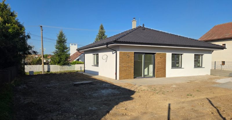 Bungalov v centre obce Cabaj Čápor, Wágnerova ulica, Dom č.1 - Rodinný dom v Cabaj-Čápore s bielou fasádou a šikmou strechou.