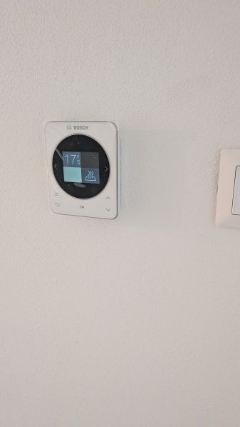 Bungalov v centre obce Cabaj Čápor, Wágnerova ulica, Dom č.1 - Termostat Bosch na bielej stene v rodinnom dome.
