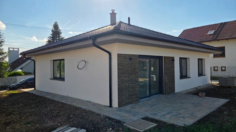 Bungalov v centre obce Cabaj Čápor, Wágnerova ulica, Dom č.1 - Exteriér rodinného domu v Cabaj-Čápore s kamenným obkladom a dláždenou terasou.