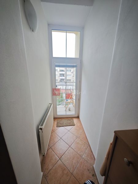 Predaj: Priestranný 2 izb byt 86m2 centrum, ul.ČSA s balkónom  - Úzka chodba s oknom a radiátorom v 2-izbovom byte, dlažba na podlahe.