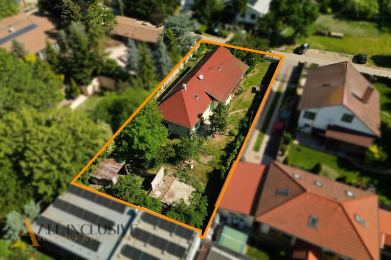 Na predaj 3-izb. rd s veľkým pozemkom, Hviezdoslavov - Rodinný dom v Hviezdoslavove s červenou strechou, obklopený zeleňou a ďalšími stavbami.