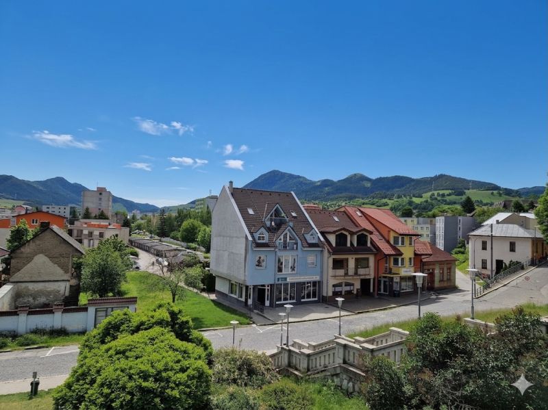 Prenájom Kancelárie 110 m² v centre Ružomberka - Pohľad na budovy a ulice v Ružomberku, s zelenými kopcami v pozadí.