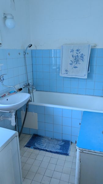 Radový domček na Zobore s výhľadom na mesto, Ružová ulica, garáž - Kúpeľňa v rodinnom dome s modrými obkladačkami a vaňou, biela umývadlo.