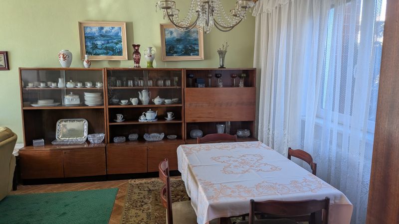 Radový domček na Zobore s výhľadom na mesto, Ružová ulica, garáž - Jedáleň v rodinnom dome s vitrínou, jedálenským stolom a dekoráciami na podlahe s dreveným dekorom.