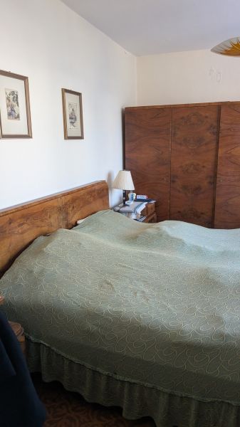 Radový domček na Zobore s výhľadom na mesto, Ružová ulica, garáž - Spálňa v rodinnom dome s dreveným nábytkom a zelenou posteľnou prikrývkou.