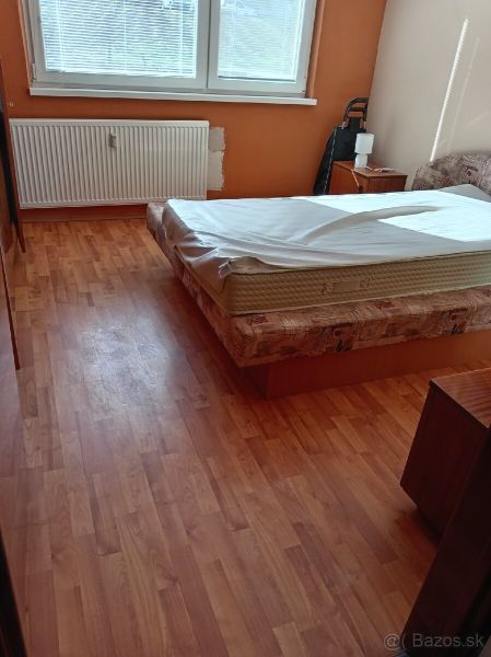 3,5 izbový byt na Klokočine, Partizánska ulica - Izba so svetlou podlahou s dreveným dekorom a jednoduchou posteľou v 3-izbovom byte.