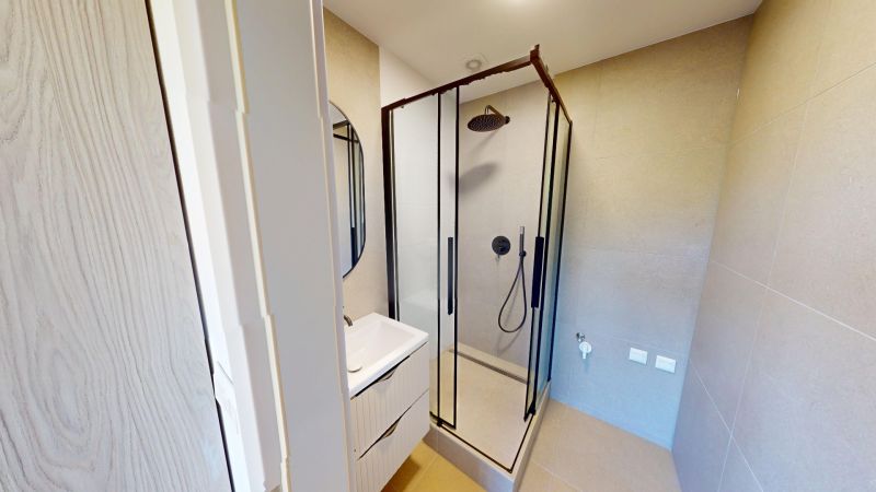Na predaj kompletne zrekonštruovaný 3-izbový byt v Trenčíne - Kúpeľňa v 2-izbovom byte s preskleným sprchovacím kútom a umývadlom.