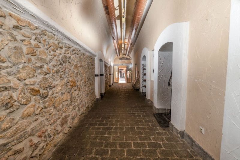 Reprezentatívny meštiansky dom s parkovaním v centre Banskej Bystrice  - Chodba so kamennou stenou a oblúkovým stropom v Zvláštnych nehnuteľnostiach.
