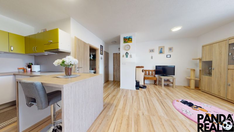 Moderný 3-izbový byt s balkónom a 2 parkovacími miestami - Ludanice - Kuchyňa a obývačka s podlahou s dreveným dekorom v 3-izbovom byte.