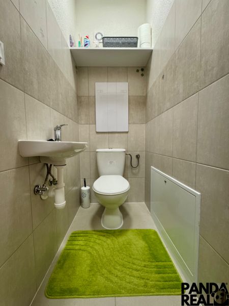 Moderný 3-izbový byt s balkónom a 2 parkovacími miestami - Ludanice - Toaleta v 3-izbovom byte s poličkou a zelenou rohožou.