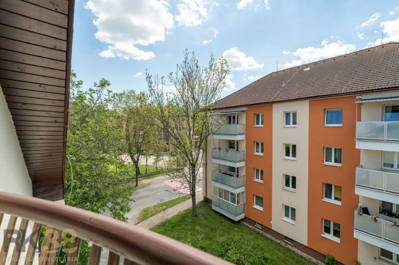 Exkluzívny 3-izbový podkrovný byt s krbom a balkónom - Výhľad z balkóna 3-izbového bytu v Poprade na okolitú zeleň a bytovú budovu.