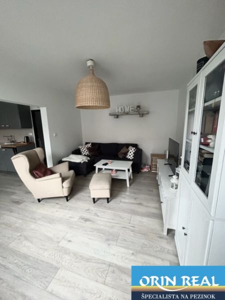 NA PRENÁJOM Pekný 2 izbový byt v Centre Pezinka 700,- EUR - Obývačka v 2-izbovom byte s podlahou s dreveným dekorom a pohodlným nábytkom.