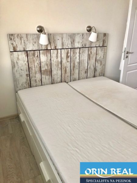 NA PRENÁJOM Pekný 2 izbový byt v Centre Pezinka 700,- EUR - Dvojlôžko v 2-izbovom byte so stene s dreveným dekorom a lampami.