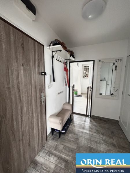 NA PRENÁJOM Pekný 2 izbový byt v Centre Pezinka 700,- EUR - Chodba s podlahou s dreveným dekorom v 2-izbovom byte, vešiaková stena, zrkadlo.