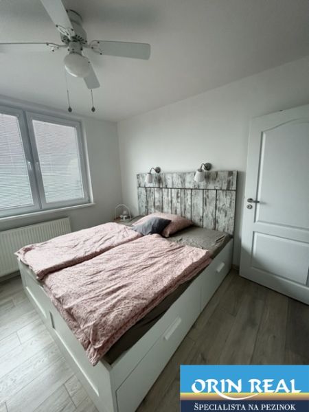 NA PRENÁJOM Pekný 2 izbový byt v Centre Pezinka 700,- EUR - Spálňa v 2-izbovom byte s podlahou s dreveným dekorom a dvojposteľou.