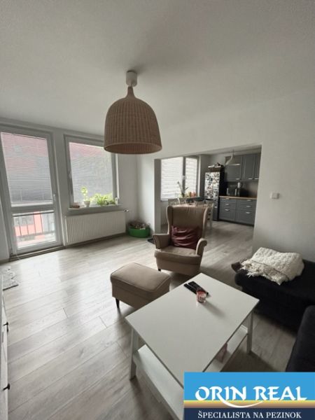NA PRENÁJOM Pekný 2 izbový byt v Centre Pezinka 700,- EUR - Obývacia izba v 2-izbovom byte s podlahou s dreveným dekorom a nábytkom.