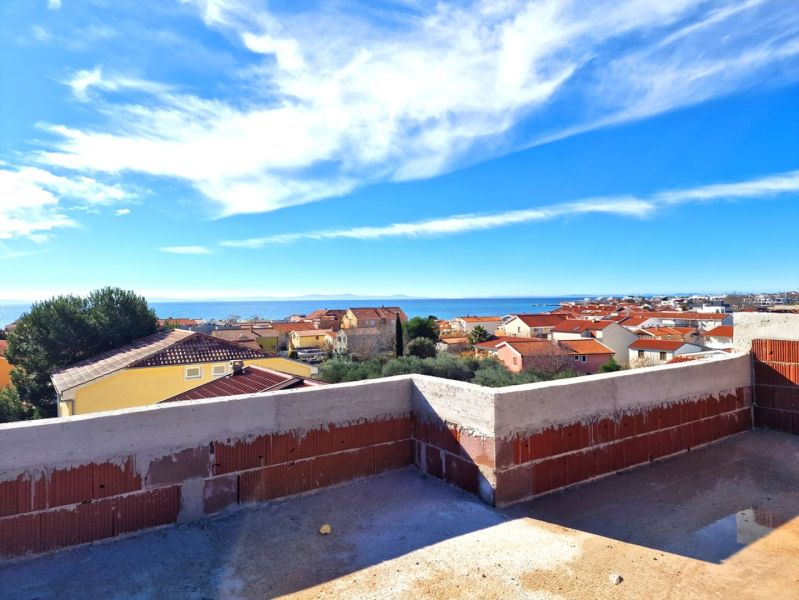 CHORVÁTSKO - 3 izbové apartmány PRIVLAKA, ZADAR - Výhľad z terasy 3-izbového bytu v Privlake na more a strechy domov.