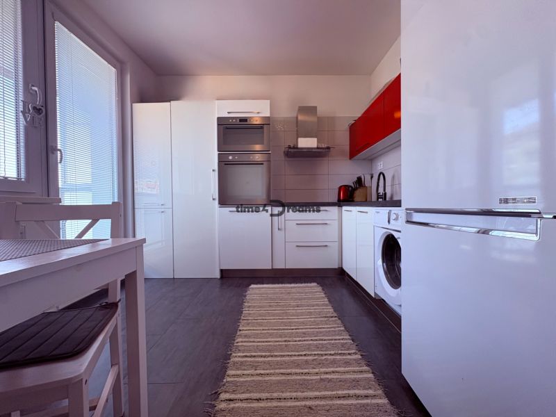 Na predaj: 4 izb.byt + BALKON + PIVNICA - Kuchyňa 4-izbového bytu s bielymi skrinkami a tmavou podlahou s dreveným dekorom.