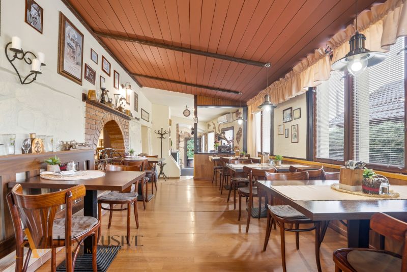 Na predaj zabehnutá reštaurácia s klientelou, Nitra - Gastro priestory s podlahou s dreveným dekorom, stolmi a dekoráciami na stenách.